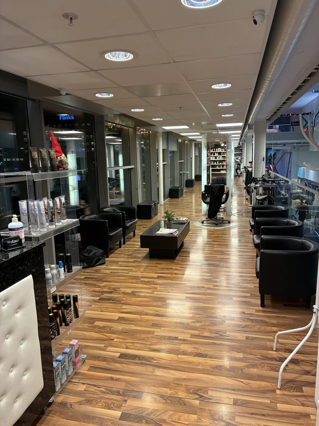 Väntrum med svarta fåtöljer och arbetsplatser längs glasväggen